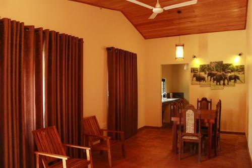 een eetkamer met gordijnen en een tafel en stoelen bij Sakura Holiday Home in Anuradhapura