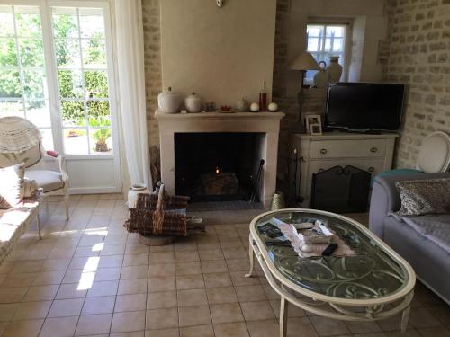 a living room with a couch and a fireplace at La bretonniere in Formigny