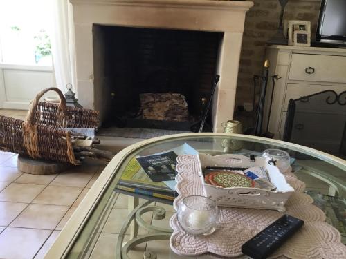- une table en verre dans le salon avec cheminée dans l'établissement La bretonniere, à Formigny