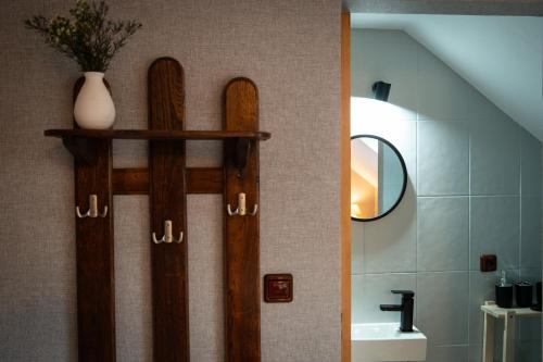 a bathroom with two wooden doors and a sink at Pensjonat Zakątek in Lidzbark