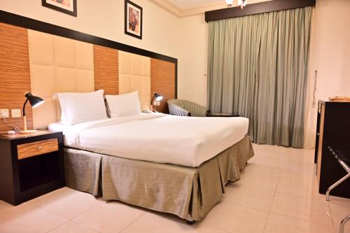 a hotel room with a large bed and a television at ديار المشاعر الهداية الفندقية Diyaralmashaer Al-Hadiyah Hotel in Makkah