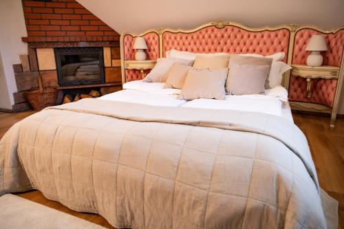 a large bed in a room with a fireplace at Pensjonat Zakątek in Lidzbark