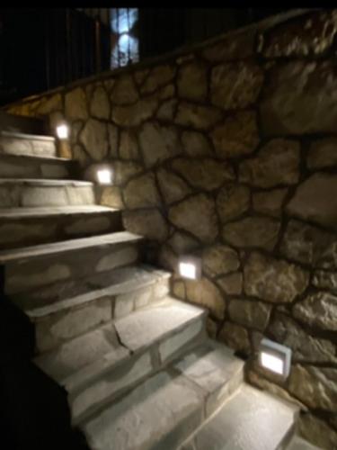 a stone wall with some lights on the stairs at ΧΑΡΟΥΛΑ ΣΤΟΥΝΤΙΟ 2 in Pávliani