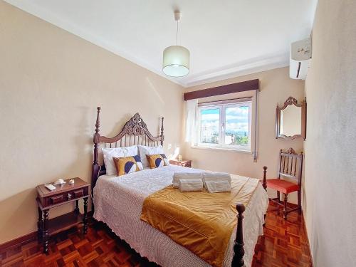 a bedroom with a large bed and a window at Cantinho da Lourdes e Tonito Nº 136193/AL in Miro