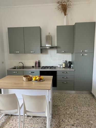 una cucina con tavolo e ciotola di frutta di Central Maruggio Appartment a Maruggio