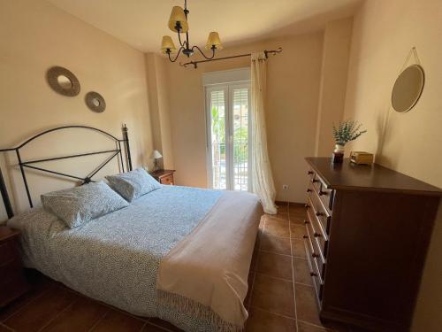 1 dormitorio con 1 cama, vestidor y ventana en Apartamento Isla Canela Los Cisnes, en Isla Canela
