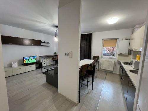 a kitchen and a living room with a table in a room at RBC Apartments with garden view in Cluj-Napoca