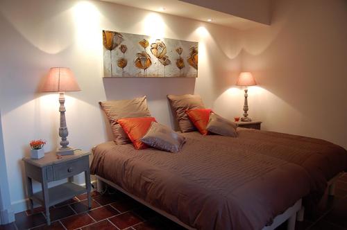 ein Schlafzimmer mit einem großen Bett mit zwei Lampen in der Unterkunft Gîtes du Vieux Tilleul, l'Ecurie. in Marseillette