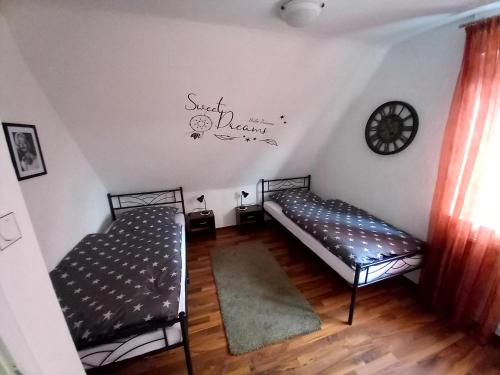 a room with two beds and a clock on the wall at Ferienwohnung u Monteurwohnung Südlohn Münsterland in Südlohn