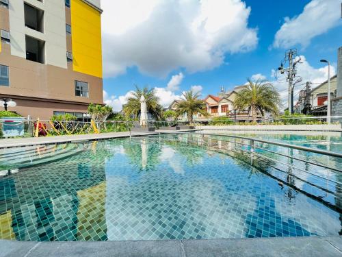 uma piscina num resort com palmeiras e um edifício em Livahome - BEE Lux homestay Di An em Dĩ An