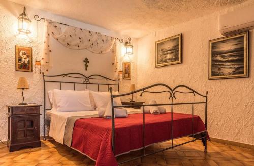 sypialnia z dużym łóżkiem i czerwonym kocem w obiekcie Casa di Soho w mieście Kalamos