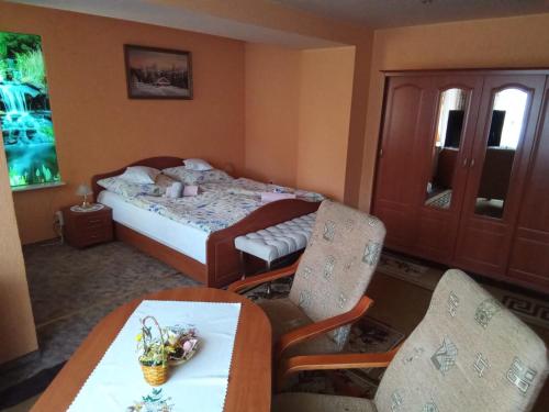 1 dormitorio con 1 cama, mesa y sillas en Rezydenz, en Szklarska Poręba