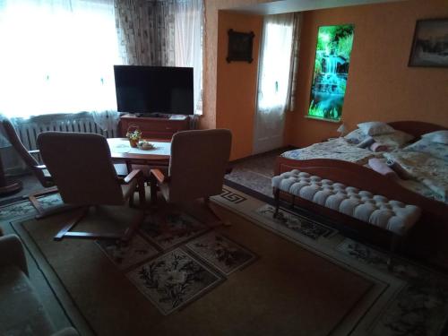 シュクラルスカ・ポレンバにあるRezydenzのベッドルーム1室(ベッド1台、テーブル、椅子付)