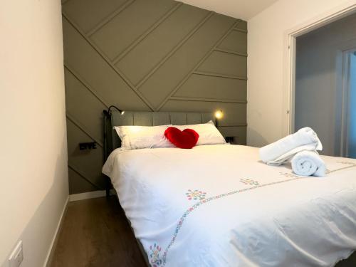 um quarto com uma cama branca com um coração vermelho em [Venezia-Mestre] Design Apartment Bros#1 em Veneza
