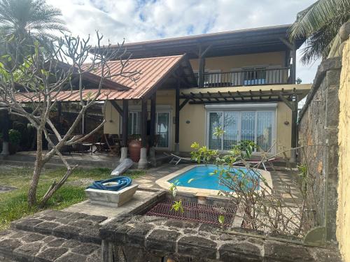 ein Haus mit Pool davor in der Unterkunft Villa Sophie in Baie du Tombeau