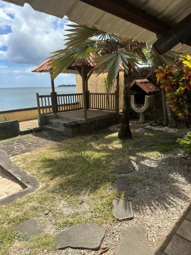 eine Terrasse mit einem Tisch und einer Palme am Strand in der Unterkunft Villa Sophie in Baie du Tombeau