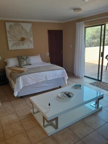 a bedroom with a bed and a table in it at Kruger Bush Retreat in Marloth Park