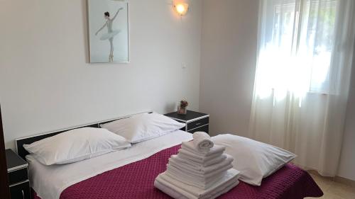 a white bed with a pile of towels on it at Luxury Apartments Villa Lenka in Podstrana
