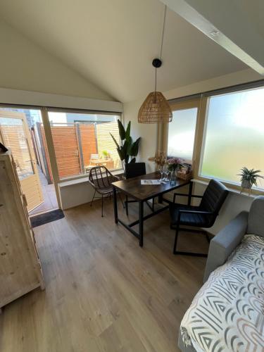 a living room with a couch and a table and chairs at Bed & Beach Noordwijk - 200m from beach and free parking in Noordwijk aan Zee