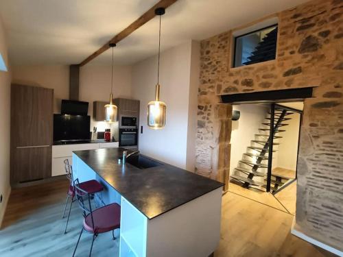 - une cuisine avec une grande île dans une pièce avec une cheminée dans l'établissement Charmante maison de village, à Le Breuil