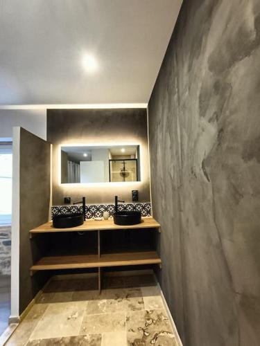 La salle de bains est pourvue de 2 lavabos et d'un miroir mural. dans l'établissement Charmante maison de village, à Le Breuil