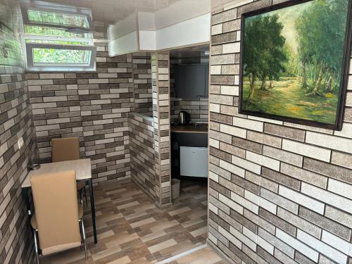 a room with a brick wall with a table and chairs at Downtown guest house in Kutaisi