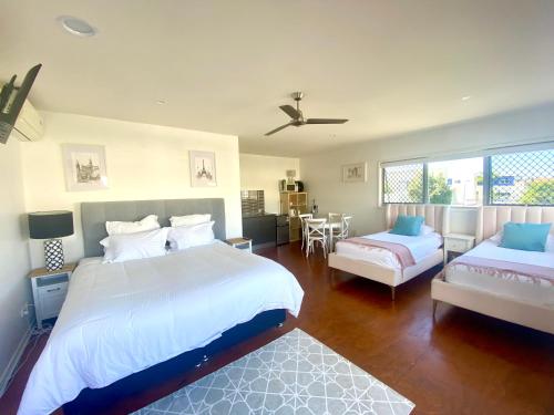 a bedroom with two beds and a couch and a table at Self contained guest house - sleeps 4 in Gold Coast