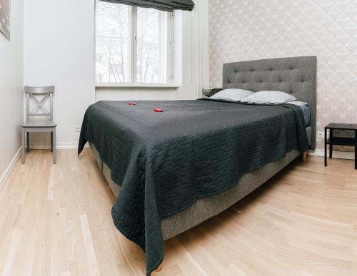a bedroom with a large bed with a green blanket at Gonsiori Apartment in Tallinn