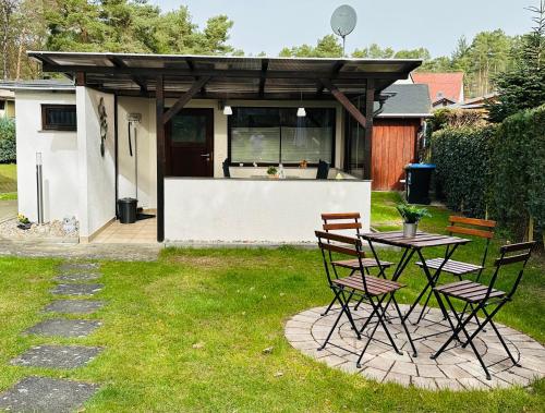 d'une terrasse avec une table et des chaises dans la cour. dans l'établissement Haus Andrea, à Himmelpfort