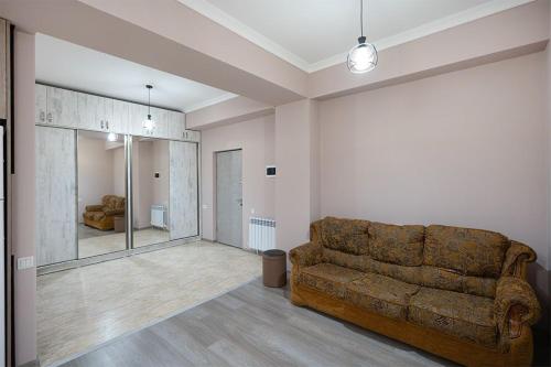 uma sala de estar com um sofá castanho num quarto em New Kond appartment em Yerevan