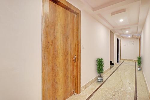 an open wooden door in a hallway with a plant at Hotel Ganga Sports in Haridwār