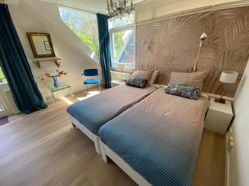 a bedroom with a large bed with a blue comforter at Park View Apartment in Amsterdam