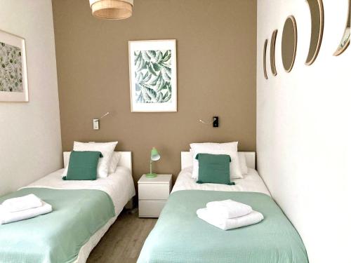 2 camas en una habitación con verde y blanco en Beau T3 lumineux : La Couronne, en Rochefort