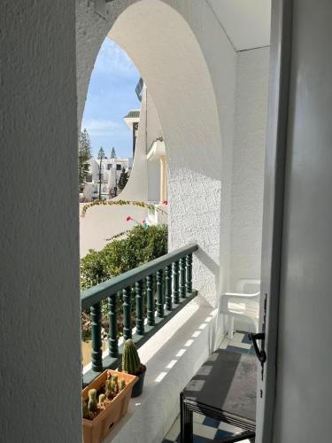 porta ad arco che conduce a un balcone con alcune piante di Bel appartement au coeur du Port El Kantaoui a Port El Kantaoui