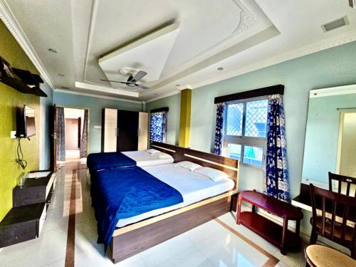 a bedroom with a large bed with blue sheets at Bobby Premium Residency in Puri