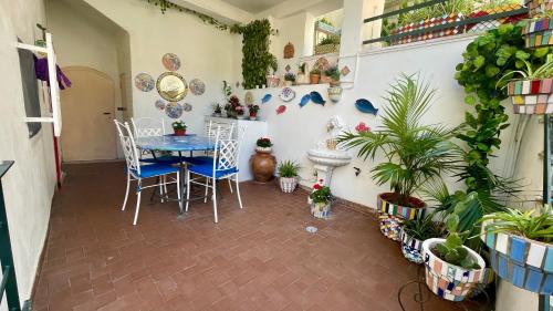 Cette chambre comprend une table, des chaises et des plantes. dans l'établissement Casa Vacanza Trono Del Sol, à Vietri