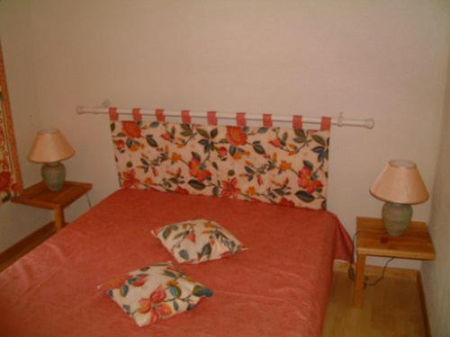 - une chambre avec un lit rouge et deux lampes dans l'établissement GITE AVEC PISCINE, à Bessèges