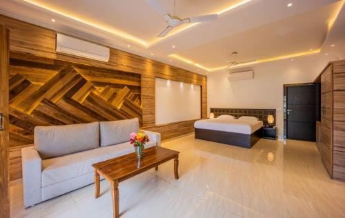 a living room with a couch and a bed at House of Celebration Goa in Bardez
