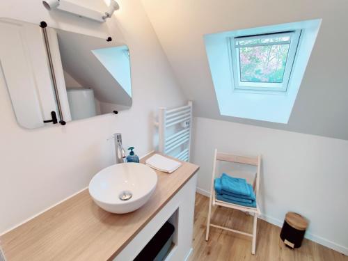 La salle de bains est pourvue d'un lavabo et d'un miroir. dans l'établissement Maison 30m2 - 1 chambre - Jardin, à Fontaine-Étoupefour