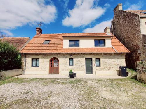 une maison en pierre avec un toit rouge dans l'établissement Maison 30m2 - 1 chambre - Jardin, à Fontaine-Étoupefour