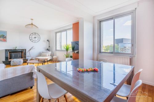 - un salon avec une grande table et des chaises en verre dans l'établissement Rêveries au bord de l’Erdre, à Nantes