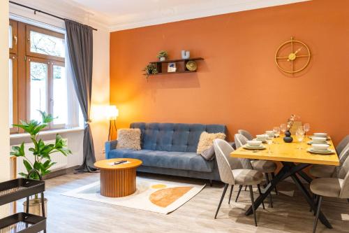 un salon avec un canapé bleu et une table dans l'établissement Familienfreundliche Stadt-Oase mit Arbeitsplatz - Bahnhofsnah, 2 Schlafzimmer, 76qm & gratis Kaffee- und Teeangebot, à Chemnitz