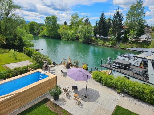 River Houses Ljubljanica في ليوبليانا: اطلاله على نهر مع مسبح و قارب