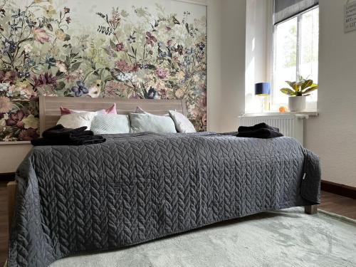 Schlafzimmer mit einem Bett mit Blumentapete in der Unterkunft Karli‘s Plätzchen in Gera