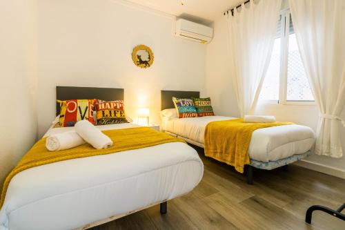 コルドバにあるApartamento Cordoba Miaの白い壁の客室で、ベッド2台、窓が備わります。
