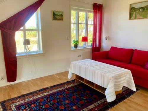 a living room with a red couch and a rug at Nära Kvarnen-Mollösund in Mollösund