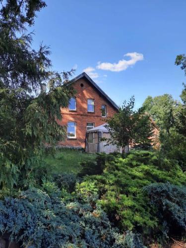 an old brick house in the middle of a garden at Stara Szkoła na Warmii in Mokiny