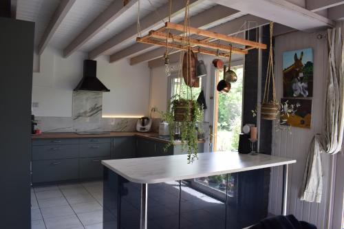 une cuisine avec des armoires bleues et une table blanche dans l'établissement Gîte les hortensias, à Crouay