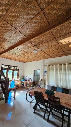 a living room with a wooden table and chairs at White house Sumatra Bukit Lawang in Timbanglawang