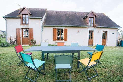 une table avec des chaises devant une maison dans l'établissement Le Beaumont • La Belle Campagne • La Plénitude, à Déols